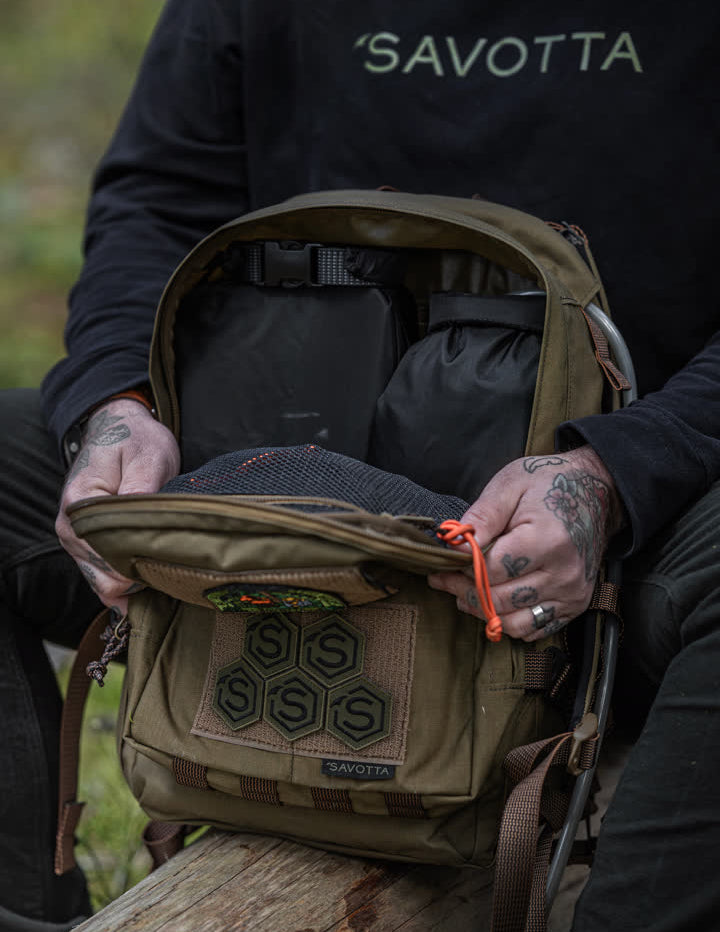 Person opening a Savotta Niukka 20L backpack with 'Savotta' branding