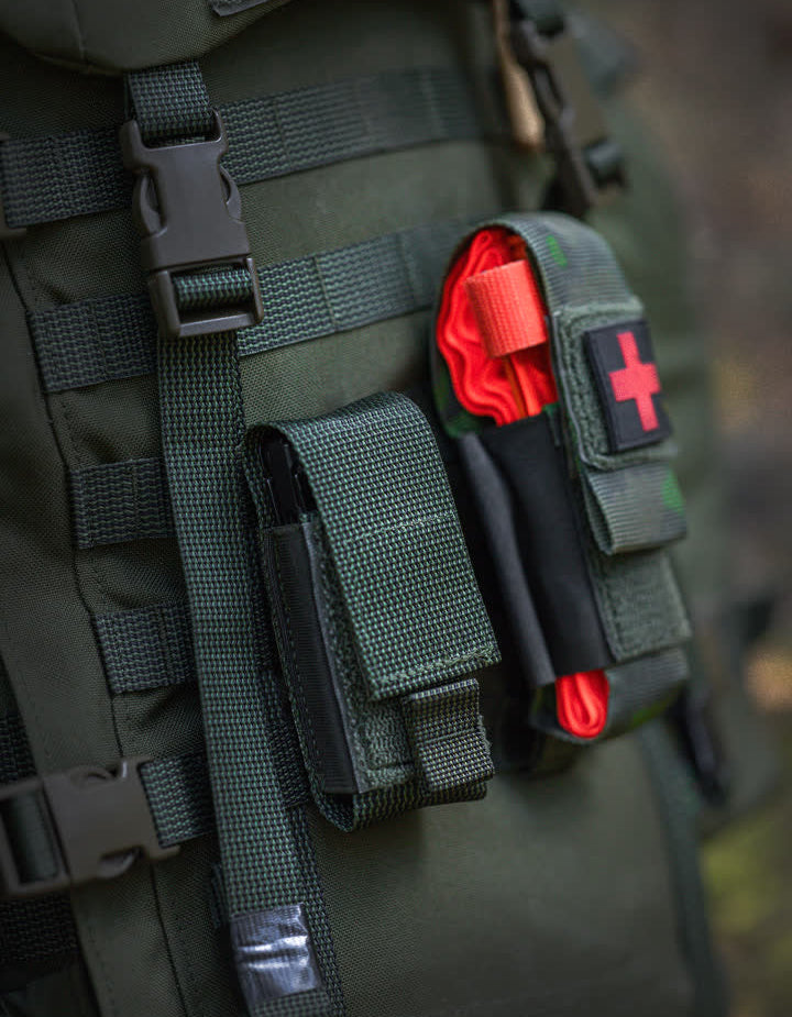Green Savotta Kantamus 40L backpack with Tourniqueat and Multitool pouches and red cross symbol.