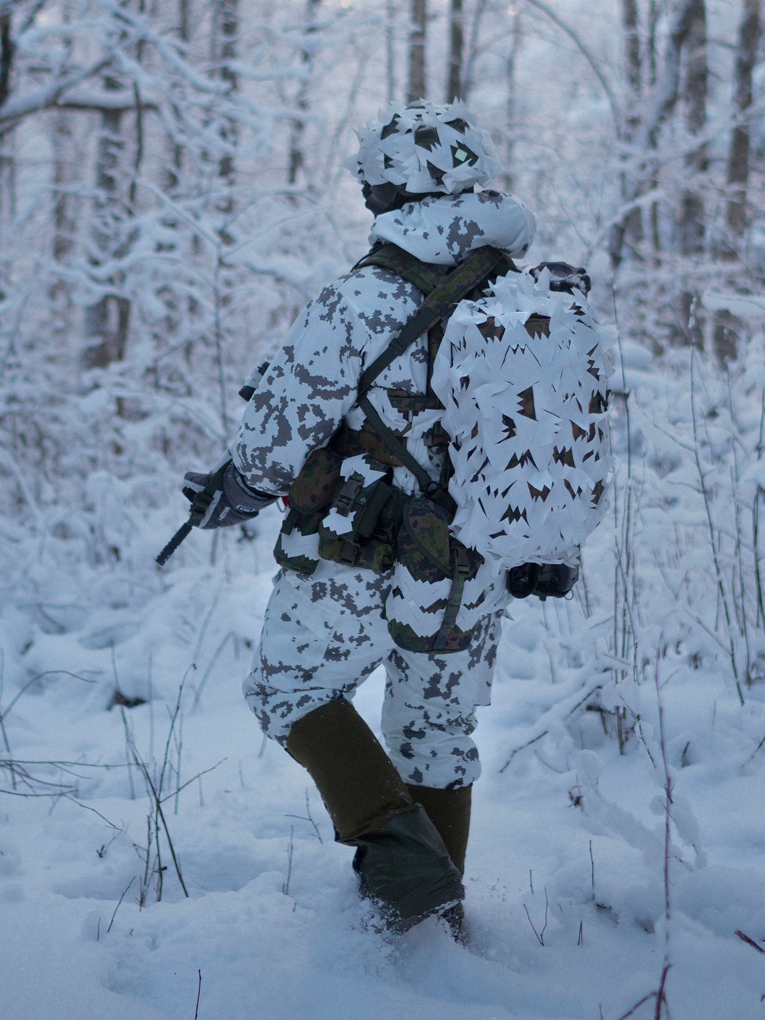 Person in snow camouflage and a Savotta Lidded GP pouch attached walking through a snowy forest