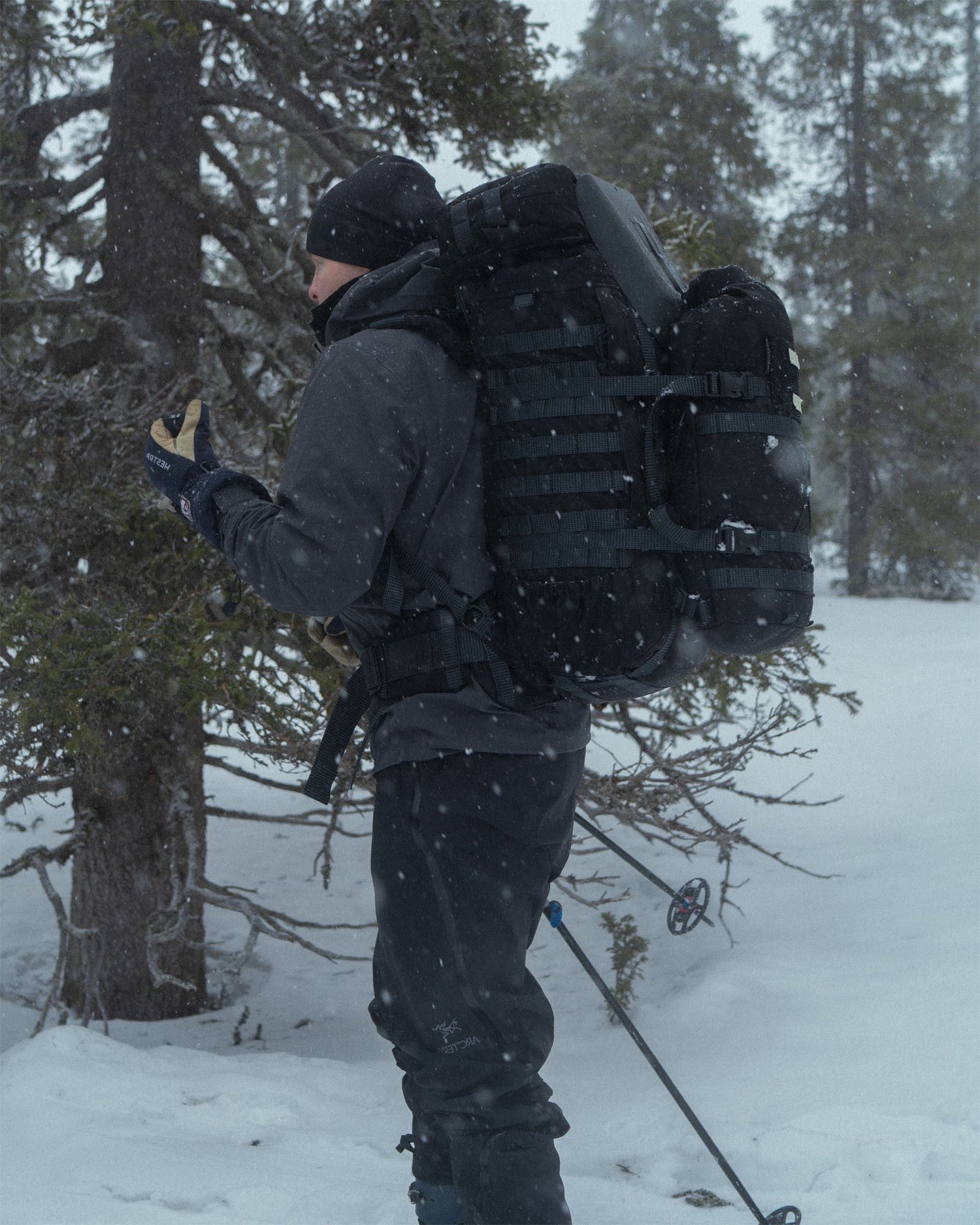 Person in winter gear with a Savotta Kantamus 40L with Savotta Hatka 12L and Askare hip pack attached in a snowy forest