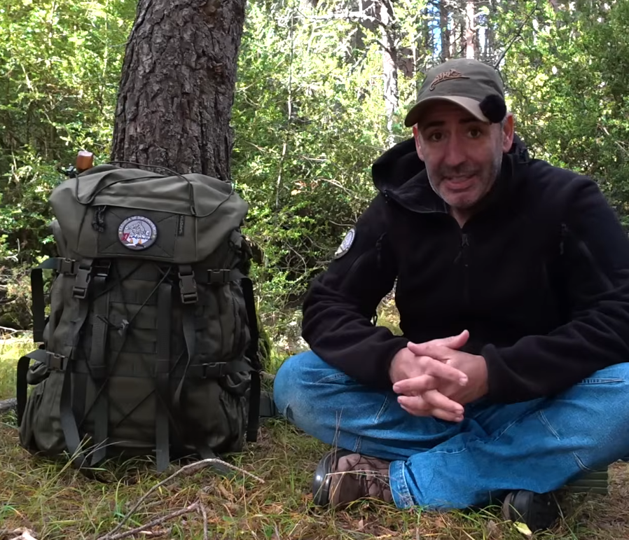 A man sitting next to a Savotta Kantamus 60L in a sunny forest
