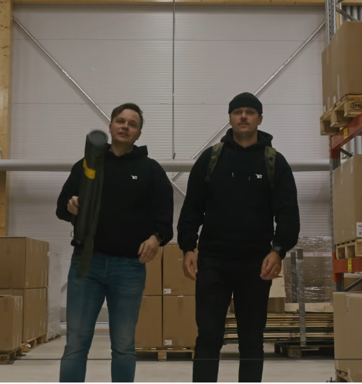 Two men standing in a warehouse setting