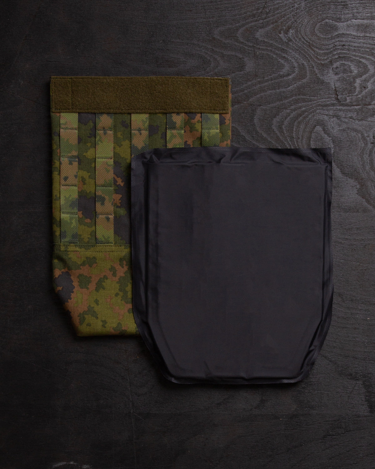 Savotta Varjelus groin flap and IIIA-panel next to it, on a dark wooden surface