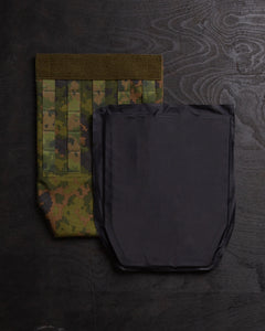 Savotta Varjelus groin flap and IIIA-panel next to it, on a dark wooden surface