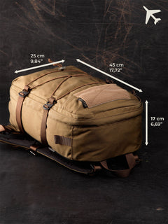 Brown Savotta Niukka 20L backpack with measurements for an airplane on a dark background