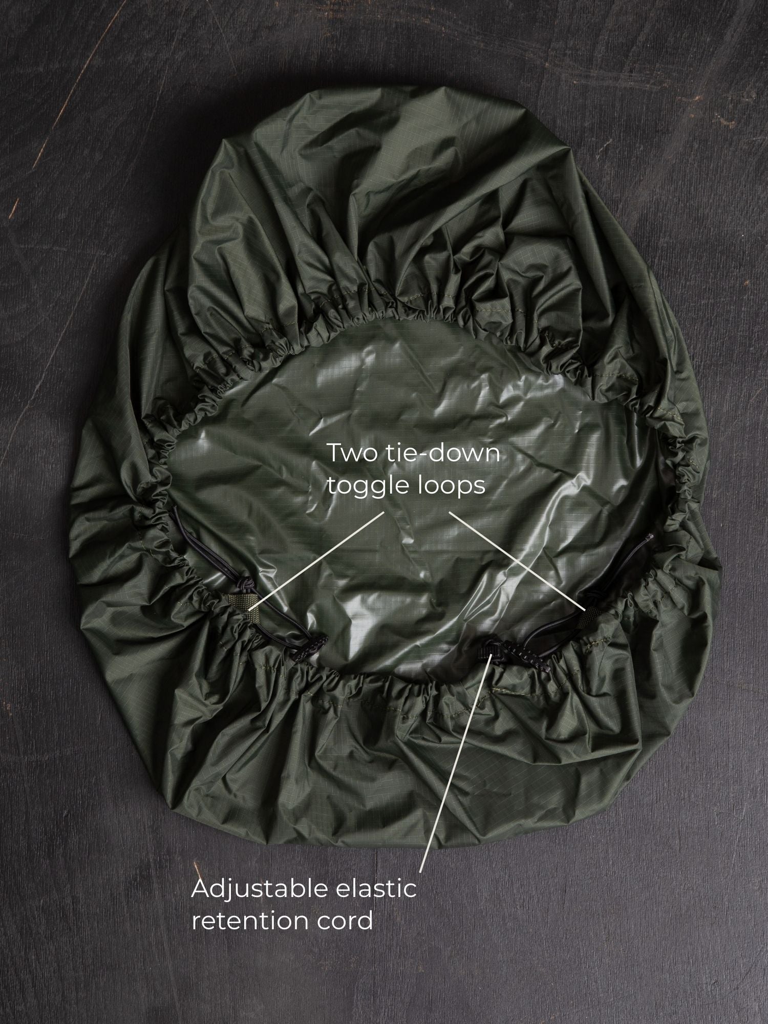 Savotta backpack cover 30L lying on a dark wooden surface with labels