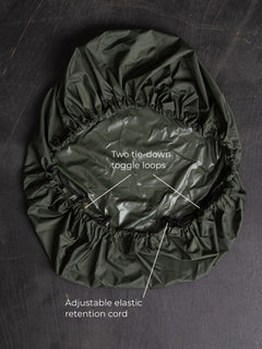 Savotta backpack cover 30L lying on a dark wooden surface with labels