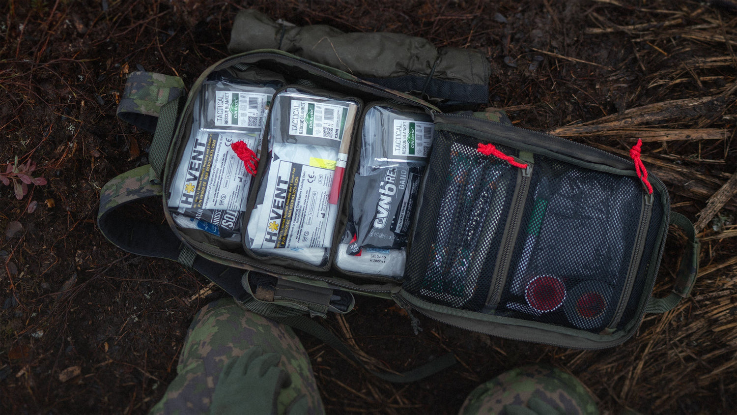 An open Savotta medic pack with visible medical supplies on a natural background.